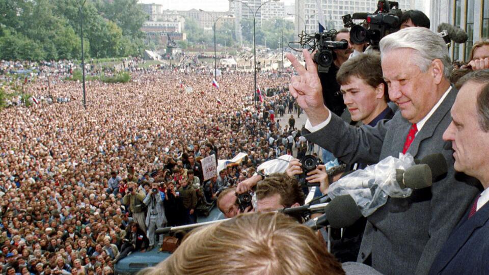 Na archívnej snímke z 22. augusta 1991 prezident Ruskej federácie Boris Jeľcin (druhý vpravo) ukazuje znak víťazstva v Moskve. Vpravo vedľa neho stojí jeho hlavný poradca Gennadij Burbulis.