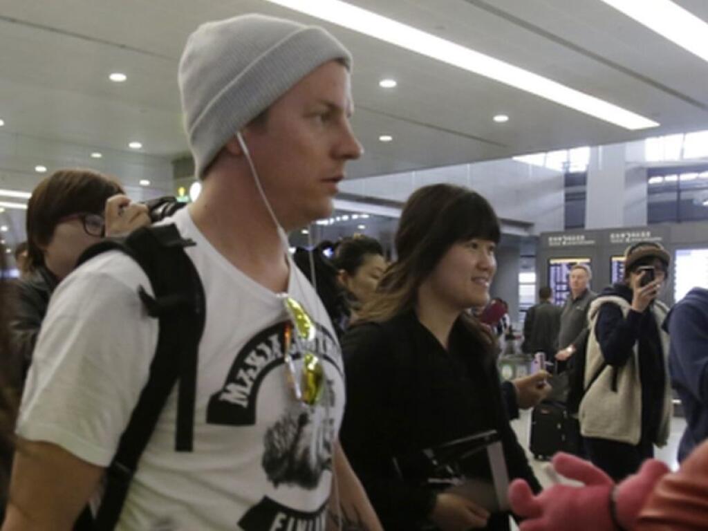 Lotus driver Kimi Raikkonen, center, of Finland is surrounded by his fans upon his arrival at Pudong International Airport ahead of Chinese Formula One Grand Prix in Shanghai, China Thursday, April 11, 2013. (AP Photo/Eugene Hoshiko)