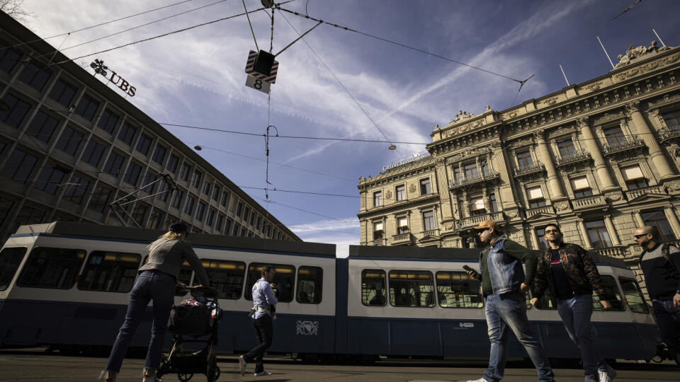 WA 57 Zürich - Ľudia kráčajú okolo sídla najväčšej švajčiarskej banky UBS a druhej najväščej švajčiarskej banky Credit Suisse v Zürichu v pondelok 20. marca 2023. UBS prevezme problémovú Credit Suisse, aby zastavila prehlbujúcu sa globálnu krízu dôvery v bankovom sektore. O fúzii dvoch najväčších švajčiarskych bánk informovali v nedeľu večer švajčiarske regulačné úrady a šéfovia oboch finančných inštitútov. FOTO TASR/AP
People walk past the headquarters of the Swiss bank Credit Suisse, right,
