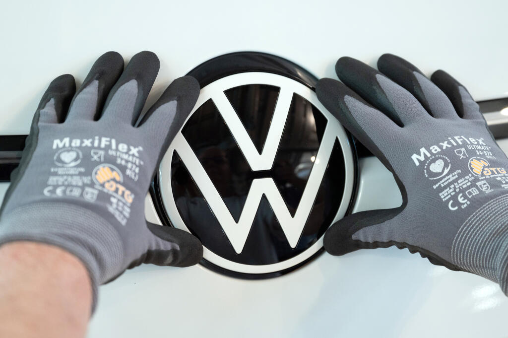PK 23 archív Drážďany - Na archívnej snímke z 8. júna 2021 pracovník fabriky nemeckej automobilky Volkswagen kladie logo na prednú časť modelu ID.3 v Drážďanoch. Agentúra DPA v pondelok 18. apríla 2022 informovala, že po približne mesiaci nútenej odstávky po zavedení lockdownu s cieľom obmedziť šírenie koronavírusového variantu omikron sa závody nemeckej automobilky Volkswagen na severovýchode Číny vracajú k produkcii. FOTO TASR/AP

ARCHIV - 08.06.2021, Sachsen, Dresden: Ein Mitarbeiter von Volk