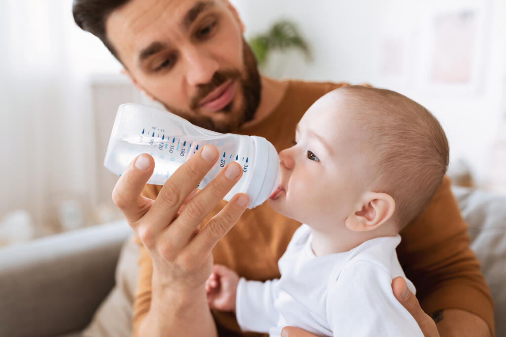 Fatherhood.,Young,Father,Giving,His,Little,Baby,Toddler,Bottle,Of