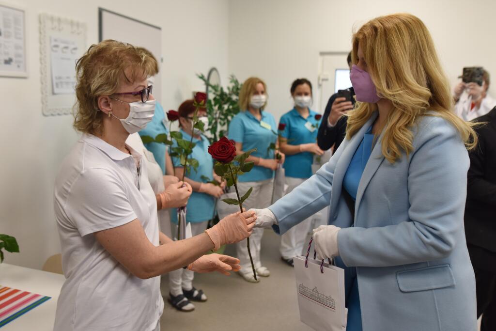 Na snímke vpravo prezidentka SR Zuzana Čaputová odovzdáva ružu a darček ako poďakovanie zamestnankyni Domova sociálnych služieb Harmónia počas pracovného výjazdu, ktorého cieľom je poďakovať ľuďom, ktorí pomáhali bojovať s koronakrízou 15. mája 2020 v Hlohovci. FOTO TASR - Lukáš Grinaj