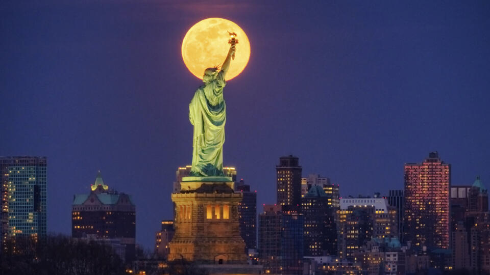 Na snímke vychádzajúci Mesiac v splne za Sochou slobody v New Yorku