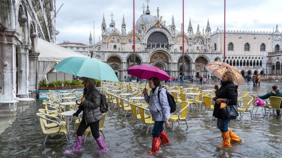 VENICE, ITALY - November 12, 2019: St. Marks Square (Piazza San Marco) during flood (acqua alta) in Venice, Italy. Venice high water. Tourists at St. Mark's Square during high water