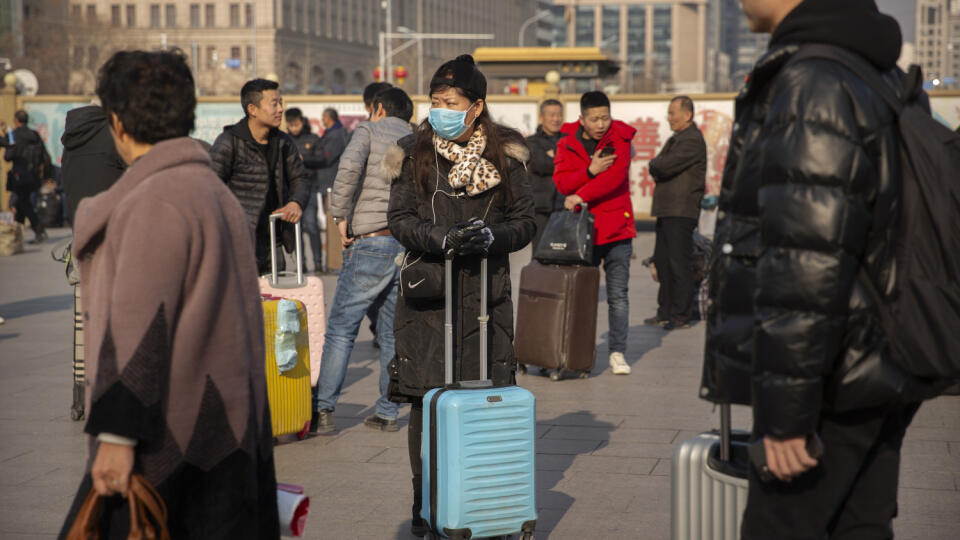 WA 12 Peking - Cestujúca, ktorá stojí pred železničnou stanicou v Pekingu, má na tvári ochranné rúško v piatok 17. januára 2020. Už druhá obeť podľahla v Číne záhadnému novému vírusu, ktorým sa nakazili desiatky ľudí a ktorý zaznamenali aj v dvoch ďalších ázijských krajinách. Druhou obeťou vírusu je 69-ročný muž. Podľa úradov zomrel v stredu v meste Wu-Chan v strednej časti Číny, ktoré je považované za epicentrum tohto nového koronavírusu patriaceho do toho istého rodu, z akého pochádza aj ťažký