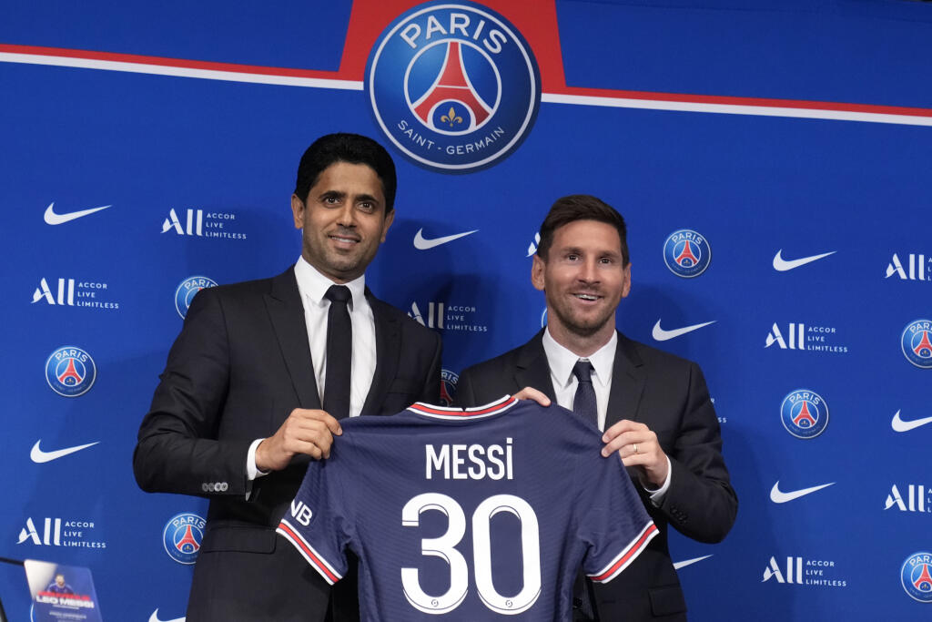 JB 34 Paríž - Argentínsky futbalista Lionel Messi (vpravo) pózuje so svojím dresom a prezident PSG Nasser Al-Al-Khelaifi počas tlačovej konferencie na štadióne Parc des Princes v Paríži 11. augusta 2021. Messi si podľa vlastných slov užíva prítomnosť v tíme Paríž St. Germain od prvých minút. Francúzsky vicemajster predstavil svoju novú hviezdnu posilu v stredu na tlačovej konferencii. Tridsaťštyriročný argentínsky útočník opustil po 21 rokoch FC Barcelona. V metropole Francúzska podpísal zmluvu