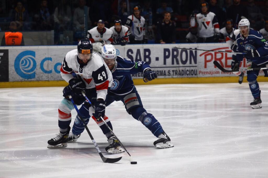 Finálový play off zápas extraligy medzi HK Nitra a HC Slovan Bratislava. Na snímke útočník Slovana, Samuel Tkáč a za ním sa hráč Nitry snaží získať puk