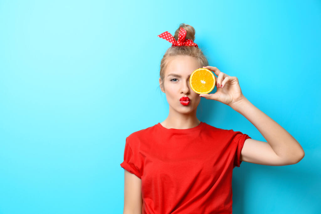 Young,Beautiful,Woman,With,Orange,On,Blue,Background