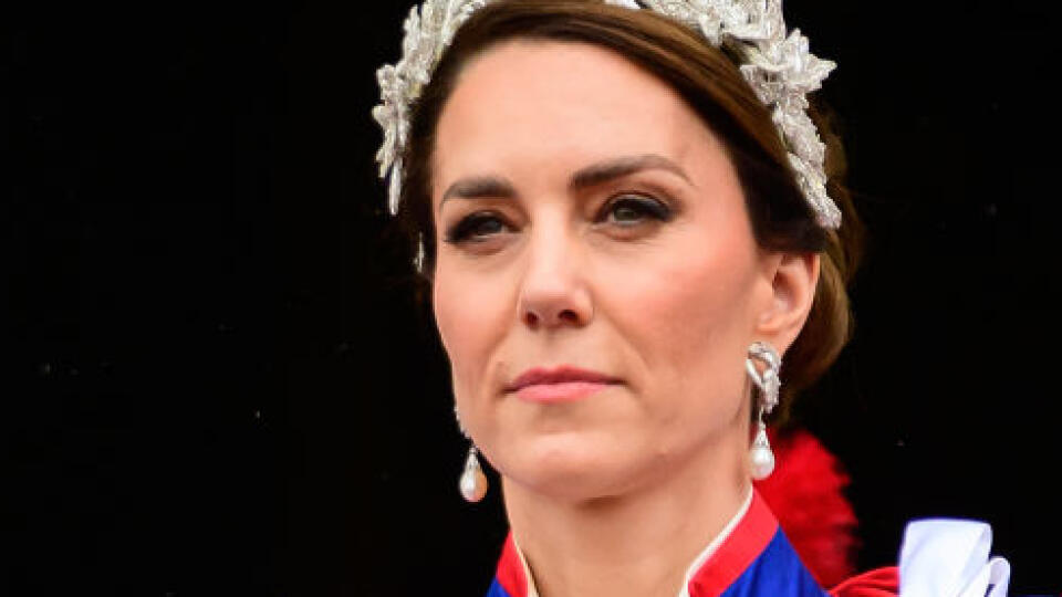 Princezná Kate mala na sebe tradičný ceremoniálny plášť. Pod ním slonovinové šaty od Alexandra McQueena a 3D čelenku, rovnako tak aj jej dcéra, princezná Charlotte.