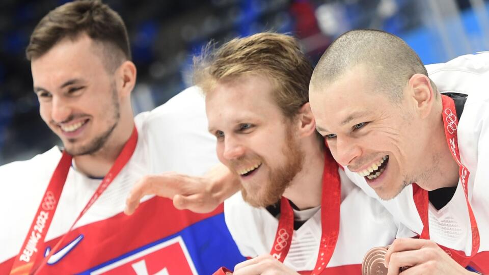 Slovenskí hráči sprava Marek Ďaloga, Michal Krištof a Matej Tomek oslavujú po zisku bronzu po zápase olympijského turnaja v hokeji mužov o bronz Slovensko - Švédsko na ZOH 2022 v Pekingu v sobotu 19. februára 2022.