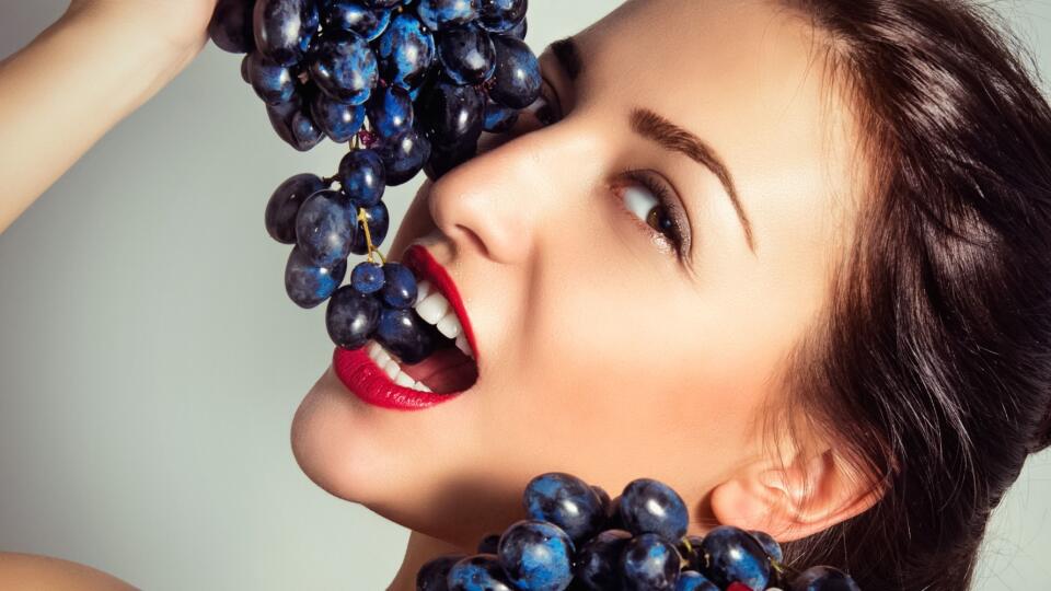 Portrait of a beautiful sexy woman with grapes.