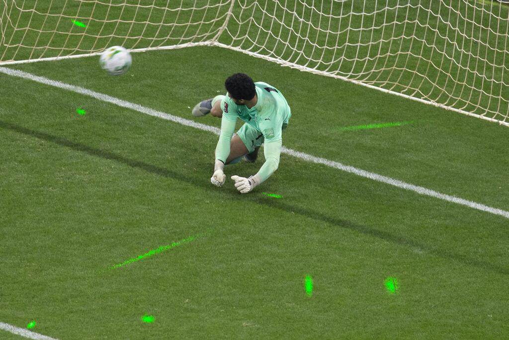 PK 7 Dakar - Egyptský brankár Mohammed El Shenawy je osvetlený zelenými laserovými svetlami počas penaltového rozstrelu v odvetnom zápase play off africkej zóny kvalifikácie na MS 2022 v Katare vo futbale Senegal - Egypt v Dakare v utorok 29. marca 2022. FOTO TASR/AP
The light from green laser pointers can be seen on the pitch AS Egypt's goalkeeper Mohamed El-Shennawy fails to stop a shot during a penalty shootout at the end of the World Cup 2022 - Africa playoff soccer match between Senegal an