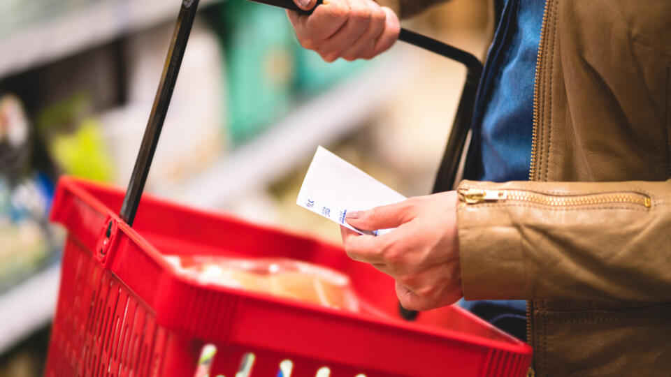 Hand,Holding,Shopping,List,And,Basket,In,Grocery,Store,Aisle.