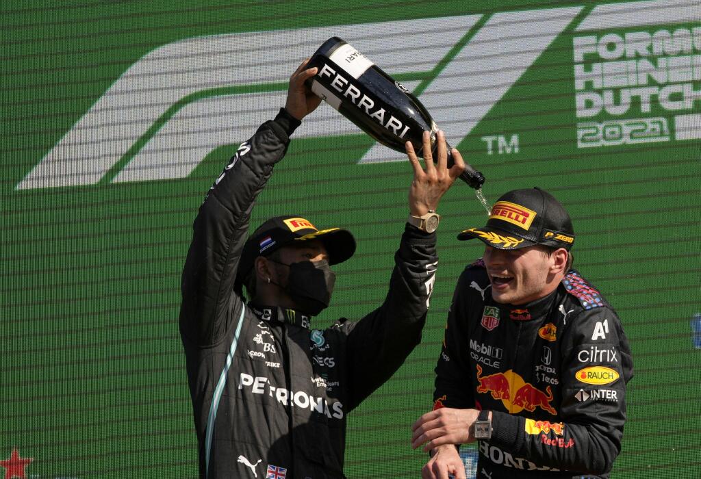 JB 64 Zandvoort - Holandský jazdec F1 na monoposte Red Bull Max Verstappen (vpravo) oslavuje na pódiu so šampanským s druhým Britom Lewisom Hamiltonom po jeho víťazstve pretekov nedeľňajšej Veľkej ceny Holandska formuly 1 na okruhu v Zandvoorte 5. septembra 2021. FOTO TASR/AP
Red Bull driver Max Verstappen of the Netherlands, right, celebrates with second placed Mercedes driver Lewis Hamilton of Britain after winning the Formula One Dutch Grand Prix, at the Zandvoort racetrack, Netherlands, Sun