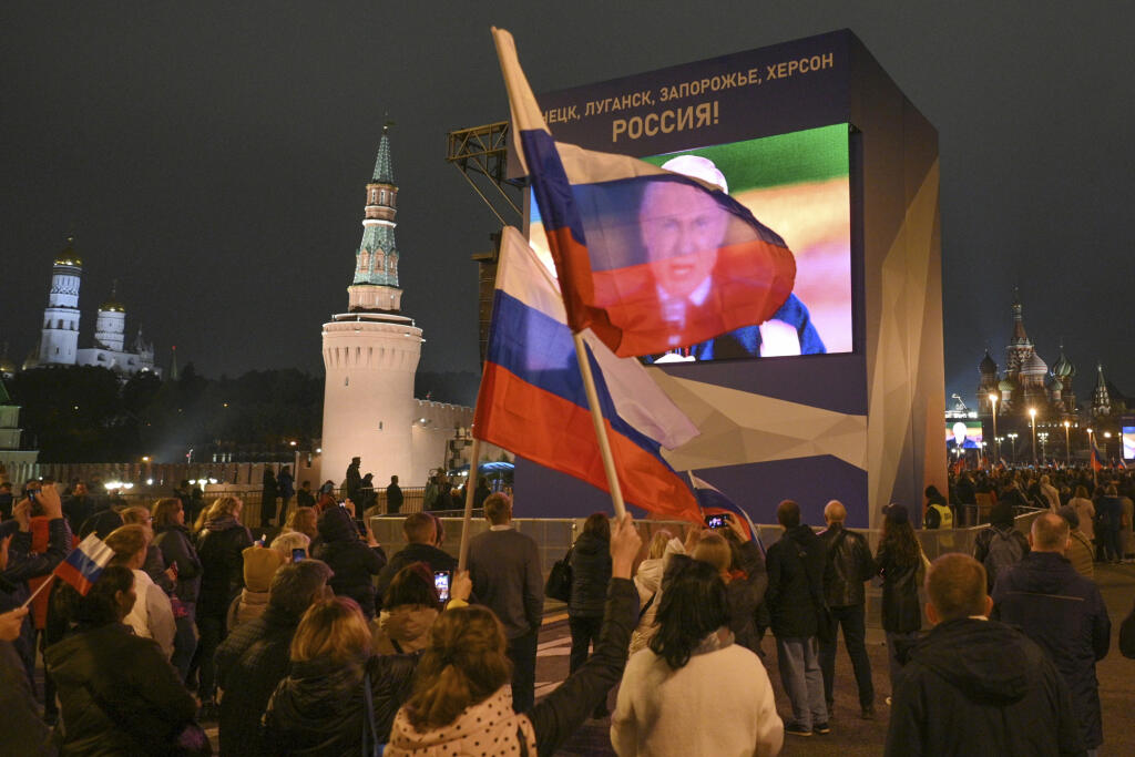 JB 50 Moskva - Ľudia sledujú na veľkoplošnej obrazovke ako ruský prezident Vladimir Putin rozpráva z Kremľa počas podpisu zmluvy o pričlenení štyroch okupovaných oblastí Ukrajiny k Rusku, na Červenom námestí v Moskve 30. septembra 2022. Putin v piatok podpísal zmluvy o pričlenení okupovaných regiónov Ukrajiny k Rusku. Zmluvy týkajúce sa Doneckej a Luhanskej oblasti a častí Chersonskej a Záporožskej oblasti boli podpísané počas ceremónie v Kremli. Začal sa tým proces ich anektovania v rozpore s m