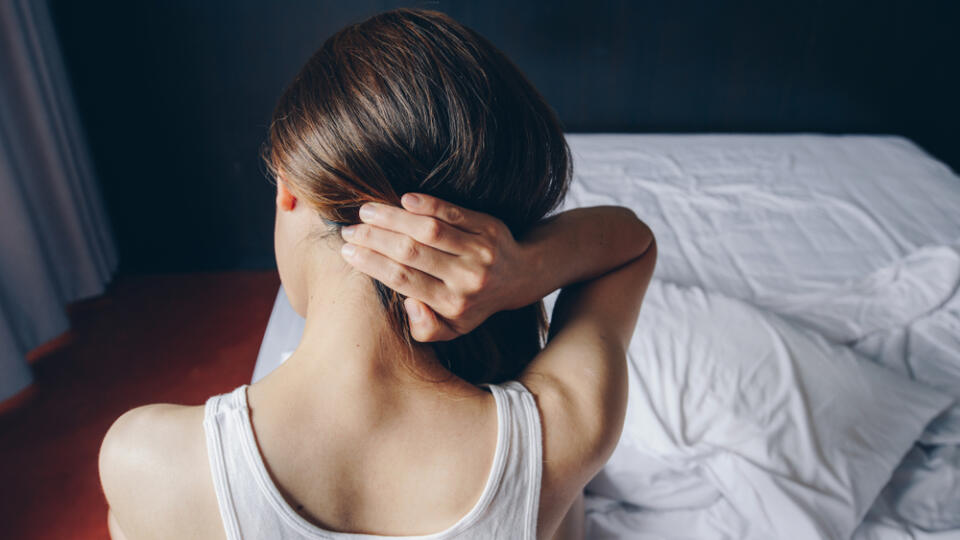 Back,View,Of,Young,Asian,Woman,Sitting,On,Bed,Having