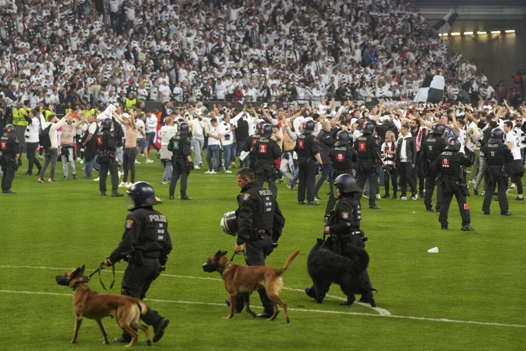 Príslušníci poriadkovej polície sa pokúšajú vytlačiť fanúšikov Frankfurtu z ihriska po tom, ako naň vtrhli po postupe do finále v odvete semifinále Európskej ligy Eintracht Frankfurt - West Ham United vo Frankfurte 5. mája 2022.