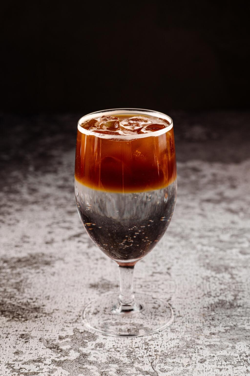 Cocktail with half of coffee and water in black background