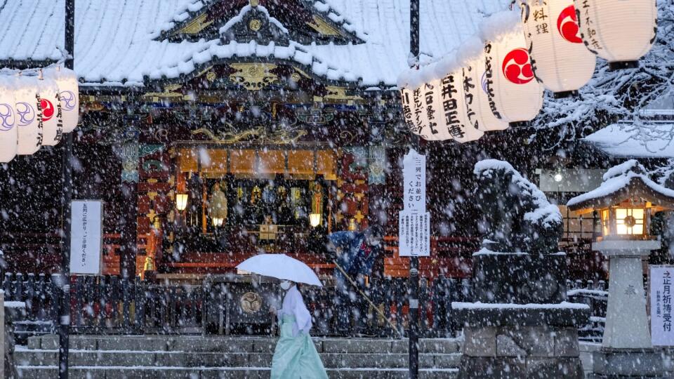 KK41 Tokio - Žena kráča okolo svätyne počas hustého sneženia 6. januára 2022 v Tokiu. Snehová pokrývka v japonskej metropoly Tokio spôsobila vo štvrtok zrušenie viac ako 100 vnútroštátnych letov. FOTO TASR/AP
A shrine maiden walks past the main shrine while a worker clears the steps as the snow comes down Thursday, Jan. 6, 2022, in Tokyo. (AP Photo/Kiichiro Sato)
