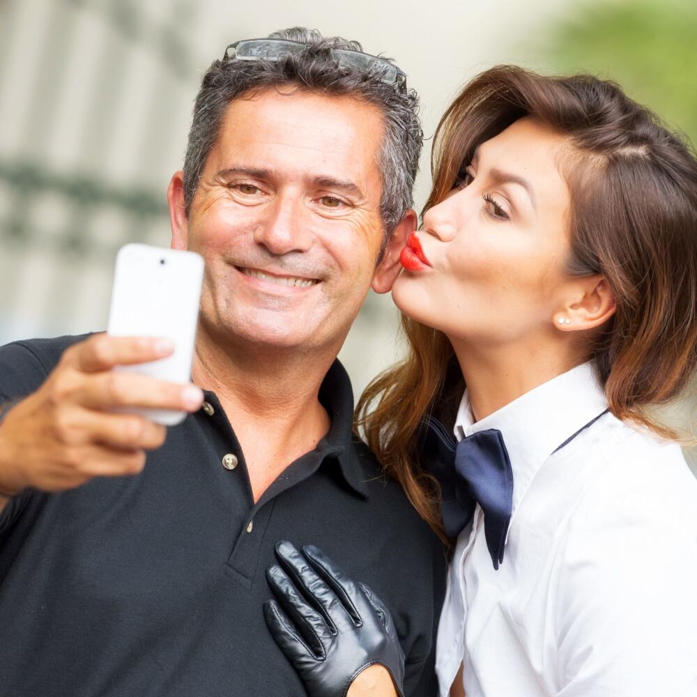 Picture of a couple taking a self picture with his smart phone