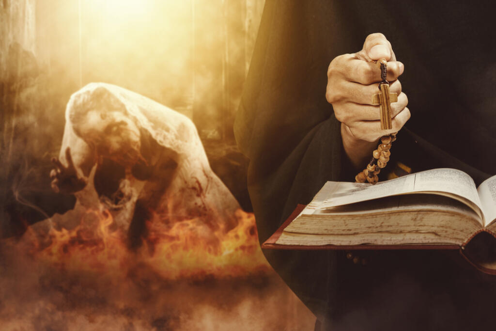 Close,Up,Of,Exorcist,Hands,Holding,A,Cross,And,Bible