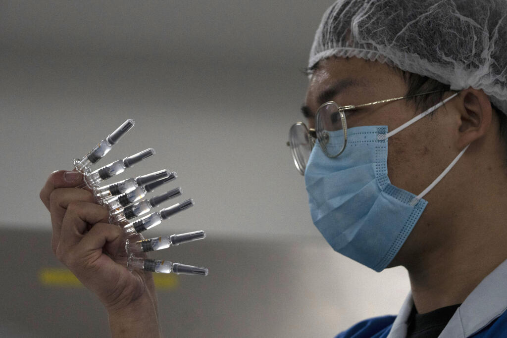 WA 24 Peking - Zamestnanec kontroluje ampulky s experimentálnou vakcínou proti novému typu koronavírusu v závode farmaceutickej firmy  SinoVac v Pekingu 24. septembra 2020. Čínske farmaceutické firmy ponúkajú od júla tri experimentálne vakcíny. Dve z nich vyvinula firma Sinopharm Group a tretiu Sinovac Biotech. Štvrtú vakcínu, ktorú používa čínska armáda, vyvinula firma CanSino Biologics. FOTO TASR/AP 

An employee manually inspects syringes of the SARS CoV-2 Vaccine for COVID-19 produced by Sin