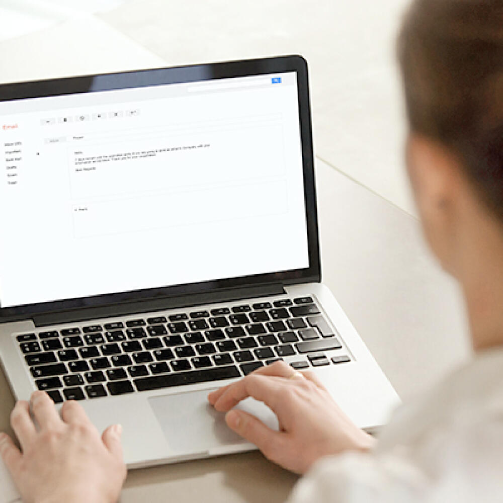 Businesswoman,Typing,E-mail,On,Laptop,At,Office,Desk,,Composing,Professional