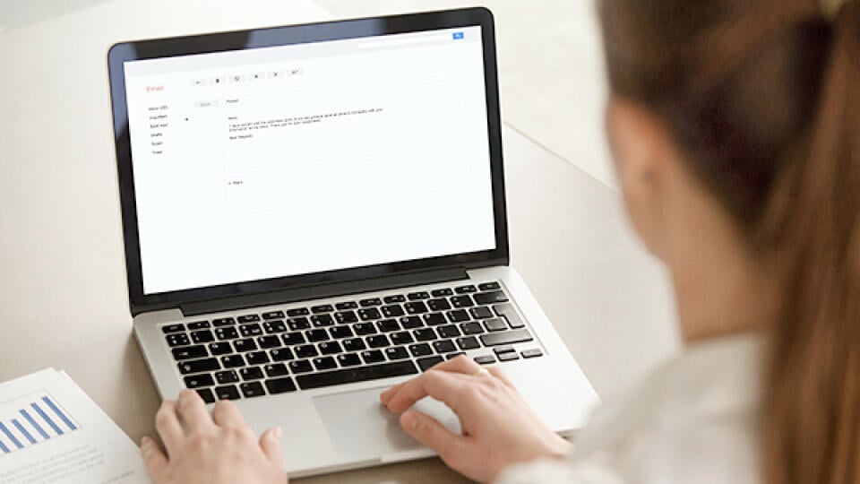 Businesswoman,Typing,E-mail,On,Laptop,At,Office,Desk,,Composing,Professional