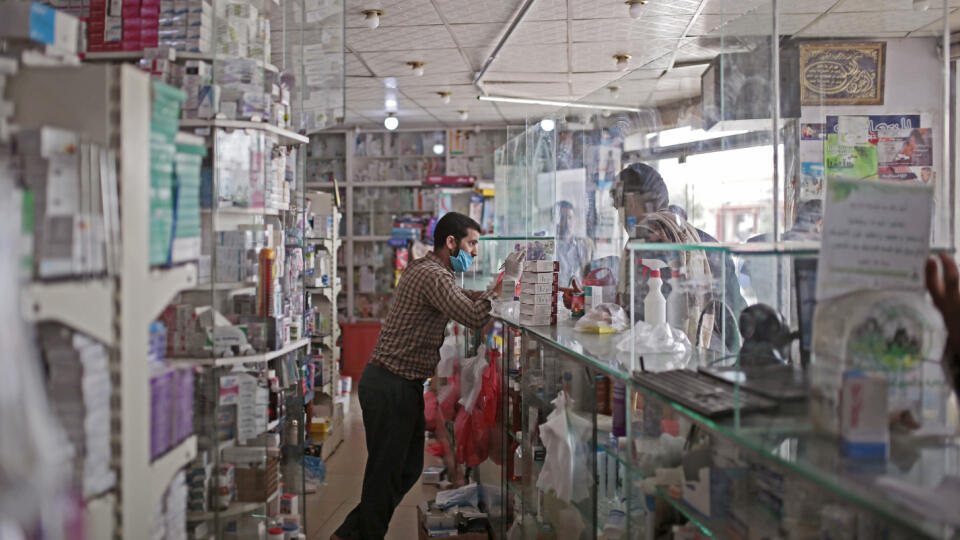 JB 16 Saná - Jemenský farmaceut s ochranným rúškom a v rukaviciach obsluhuje zákazníkov za presklenným pultom na zabránenie šíreniu nového koronavírusu v lekárni v Saná 25. júna 2020. FOTO TASR/AP
A Yemeni pharmacist wearing a protective face mask serves his customers behind a glass shield installed as a precautionary measure against the spread of the coronavirus at a pharmacy in Sanaa, Yemen, Thursday, June 25, 2020. (AP Photo/Hani Mohammed)