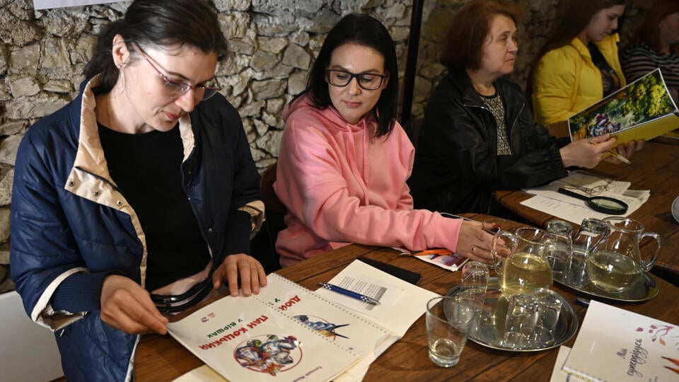 Na snímke utečenkyne z Ukrajiny listujú v rozprávkových knihách v ukrajinskom jazyku, ktoré vytlačila a darovala Trenčianska nadácia v Trenčíne v utorok 26. apríla 2022. Trenčianska nadácia spustila projekt Otvor srdce, daruj knihu pre Ukrajinu. Nadácia získala autorské práva pre vybrané ukrajinské detské knihy, ktoré dáva postupne tlačiť a rozdáva ich utečencom z Ukrajiny. Na ich tlač zbiera finančné príspevky od darcov. FOTO TASR - Radovan Stoklasa