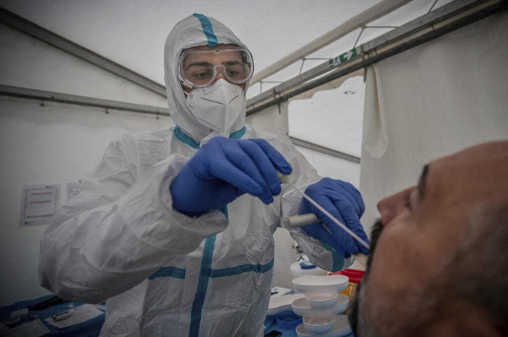 KK14 Berlín - Na snímke zdravotný pracovník odoberá vzorku na PCR test na ochorenie Covid-19 v testovacom centre na Covid-19 v Berlíne 14. októbra 2020.  Od začiatku pandémie zaznamenali v Nemecku podľa údajov RKI prinajmenšom 341.223 potvrdených prípadov nákazy novým druhom koronavírusu a 9710 súvisiacich úmrtí, z ktorých 33 pribudlo za posledný deň. Z nákazy sa tam dosiaľ vyliečilo približne 284.600 ľudí. FOTO TASR/AP
Medical personnel perform a Covid-19 PCR smear on a man at a corona test cen