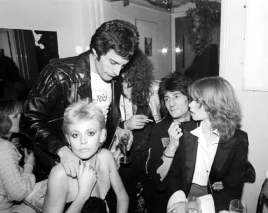 Spevák Queen Freddie Mercury a herečka Britt Ekland, a vedľa nich gitarista The Rolling Stones Ronnie Wood s druhou manželkou Jo, vpravo.