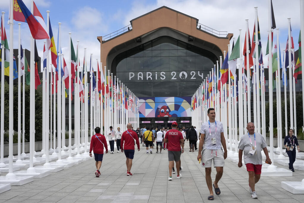 KK42 Paríž - Na snímke ľudia kráčajú pred jedálňou v olympijskej dedine pred XXXIII. letnými olympijskými hrami v Paríži v pondelok 22. júla 2024. FOTO TASR/AP
People walk in front of the canteen in the Olympic Village, at the 2024 Summer Olympics, Monday, July 22, 2024, in Paris, France. (AP Photo/Michel Euler, Pool)