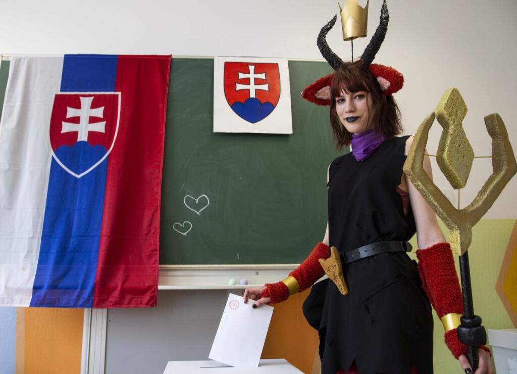 Volička v kostýme vhadzuje obálku s hlasovacím lístkom do volebnej schránky vo volebnej miestnosti na ZŠ Nevädzová 2 v B