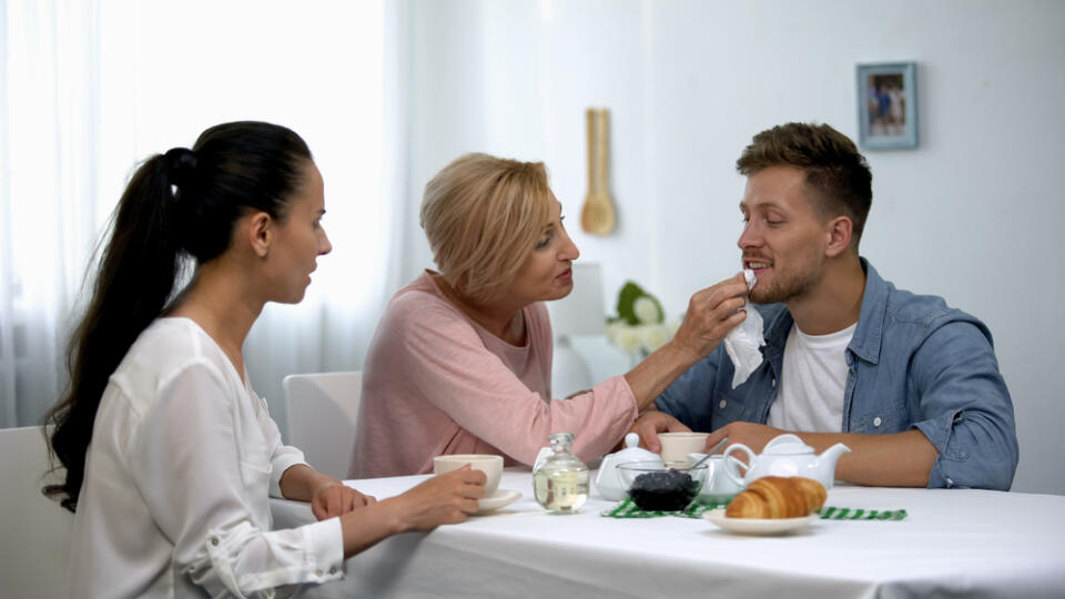 Shocked,Wife,Looking,At,Mother-in-law,Wiping,Husbands,Mouth,During,Tee