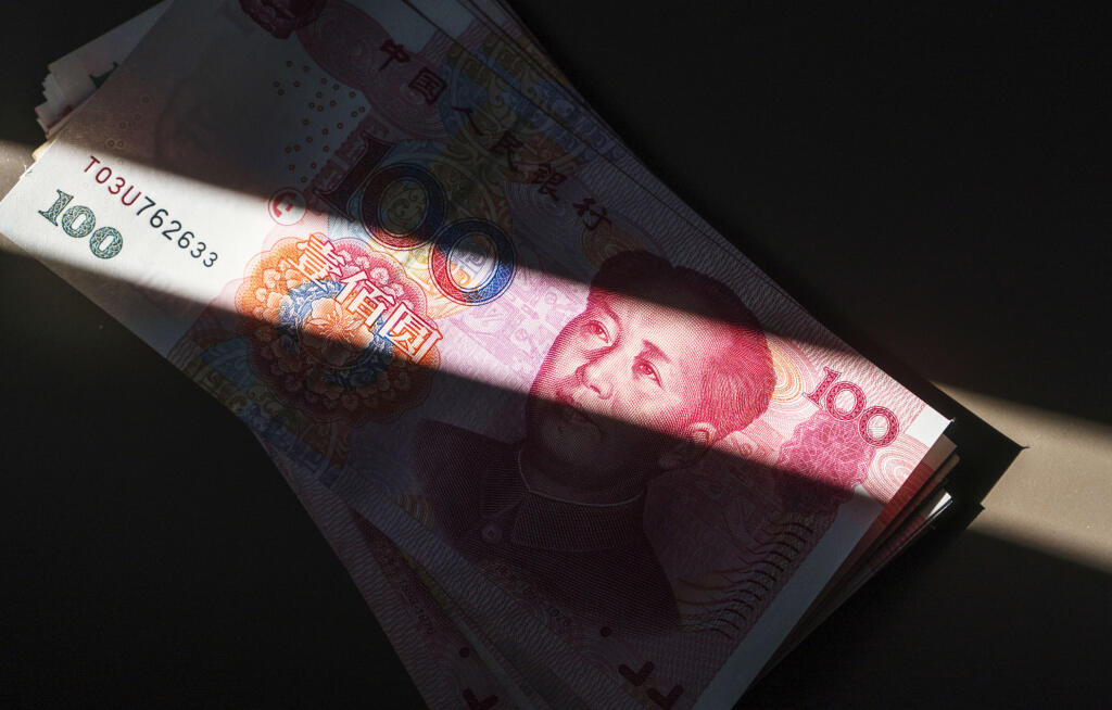 RMB banknotes arranged in a ray of sunlight.  Since the IMF