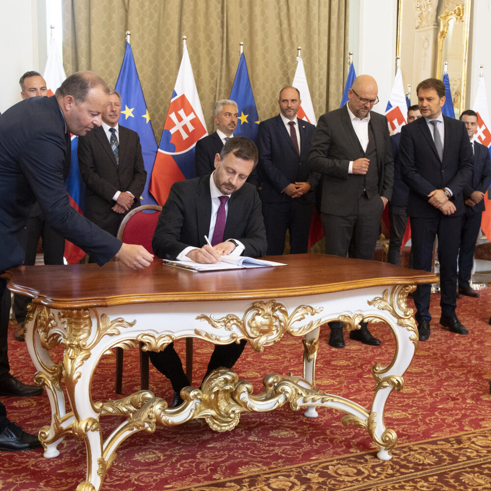 Na snímke uprostred predseda vlády SR Eduard Heger a vľavo zástupca výkonného riaditeľa Volvo Javier Varela po podpise zmluvy o výstavbe závodu Volvo v industriálnom parku Valaliky pri Košiciach. V Bratislave 1. júla 2022 v Bratislave. FOTO TASR - Pavel Neubauer