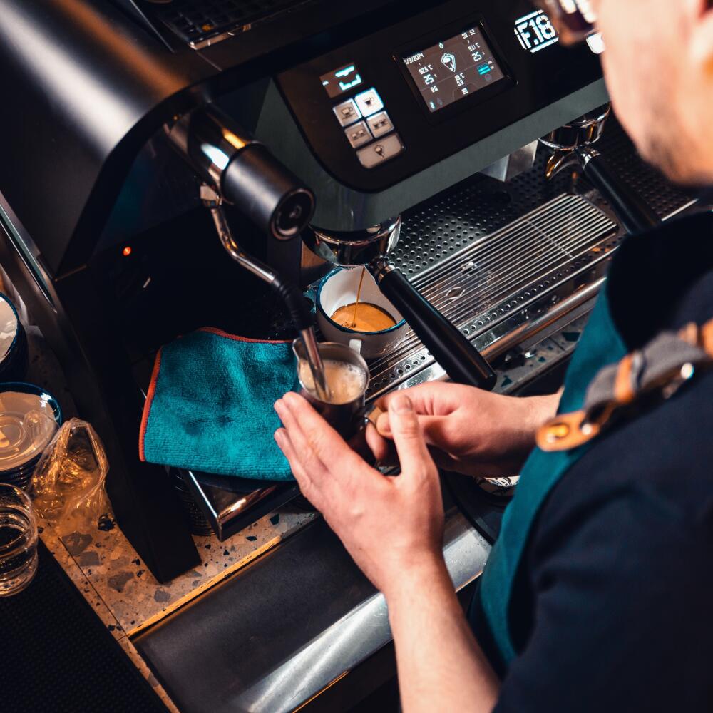 Barista working behind the counter in the cafe, getting ready to make coffee.