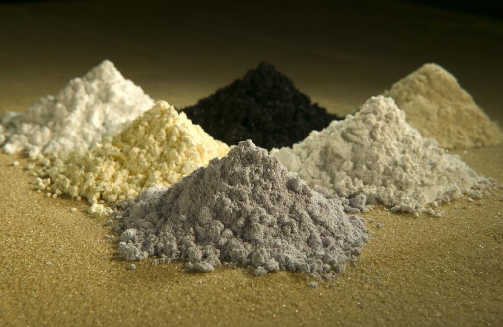 In this undated photo released by the U.S. Department of Agriculture are rare-earth oxides, clockwise from top center: praseodymium, cerium, lanthanum, neodymium, samarium, and gadolinium. Across the West, early miners digging for gold, silver and copper had no idea that one day something even more valuable would be hidden in the piles of dirt and rocks they tossed aside. Now there’s a rush in the U.S. to find key components of cellphones, televisions, weapons systems, wind turbines, MRI machine