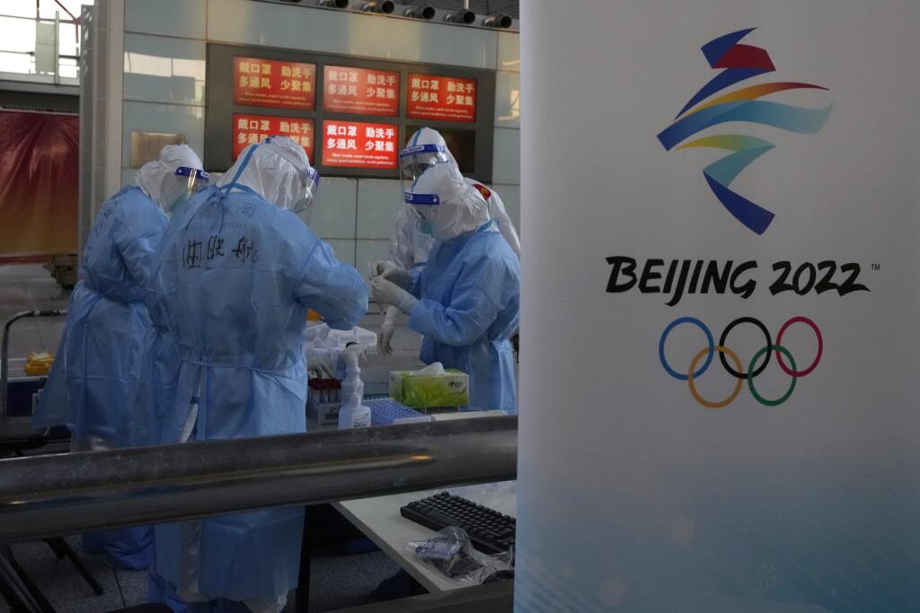 WA 24 Peking - Pracovníci odetí v špeciálnych ochranných odevoch počas príchodu účastníkov na zimné olympijské hry na letisku v Pekingu v pondelok 31. januára 2022. Organizátori ZOH 2022 v Pekingu odhalili ďalších 37 koronavírusových prípadov. Po prílete do Číny malo pozitívny test 28 ľudí, z nich ôsmi boli športovci alebo ďalší členovia tímov.  ZOH odštartujú slávnostným ceremoniálom v piatok 4. februára. FOTO TASR/AP 

Olympic workers wear protective gear as passengers arrive at the Beijing Ca