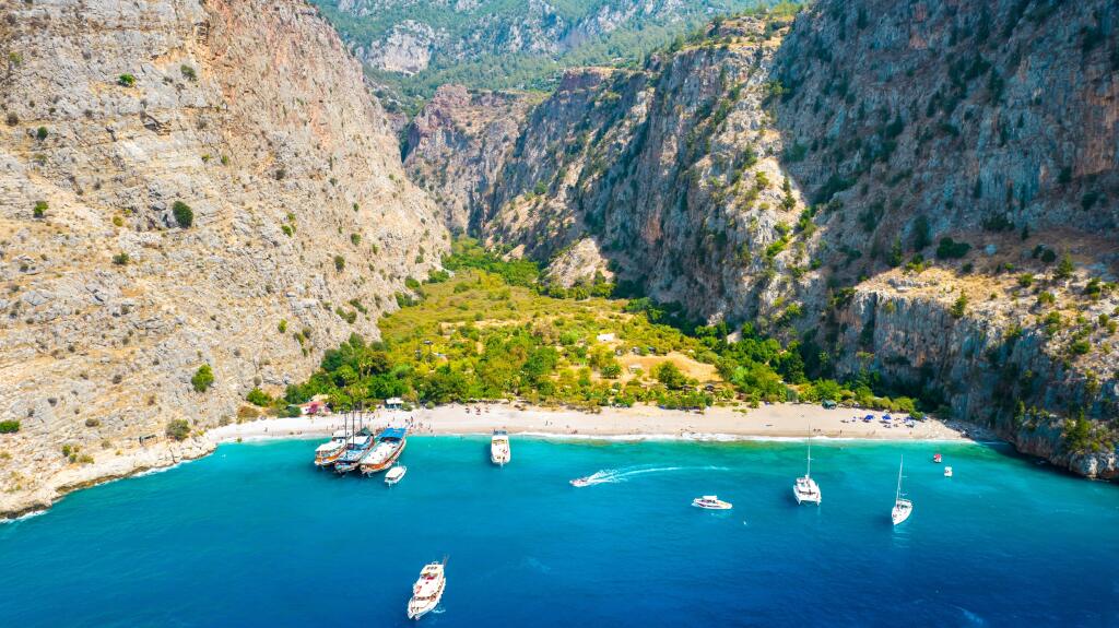 Butterfly Valley (Turkish: Kelebekler Vadisi) in Oludeniz. Aerial view with drone on beach and boats. Fethiye, Mugla, Turkey.