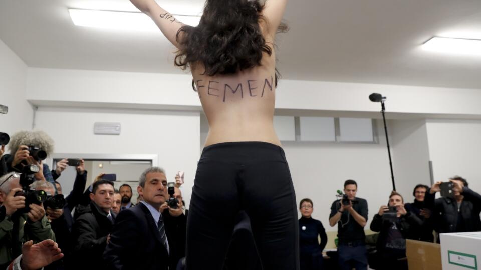 Polonahá aktivistka hnutia Femen s nápisom na hrudi  "Berlusconi, už si za zenitom" protestuje vo volebnej miestnosti, do ktorej prišiel voliť bývalý taliansky premiér líder strany Vpred Taliansko Silvio Berlusconi poèas parlamentných volieb 4. marca 2018 v Miláne. 