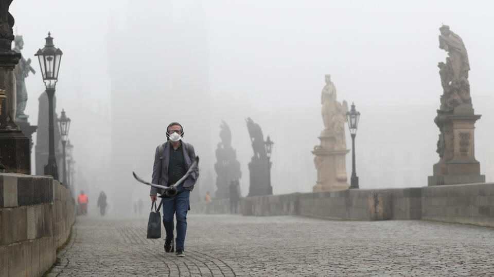 WA 34 Praha - Muž s respirátorom kráča po Karlovom moste počas hmlistého rána v Prahe v stredu 24. februára 2021. Česká republika pristúpila na ďalšie sprísňovanie epidemiologických opatrení v boji proti nákazlivejším variantom nového typu koronavírusu. V rámci členských krajín EÚ patrí Česko k jedným z najviac postihnutých krajín nákazou. Zhoršujúca epidemiologická situácia prinútila český kabinet odložiť otvorenie všetkých obchodov. FOTO TASR/AP
A man wears a face mask as he walks across the