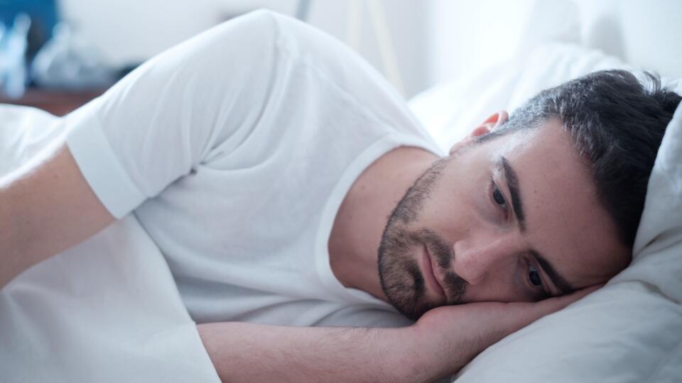 Depressed man lying in his bed and feeling bad