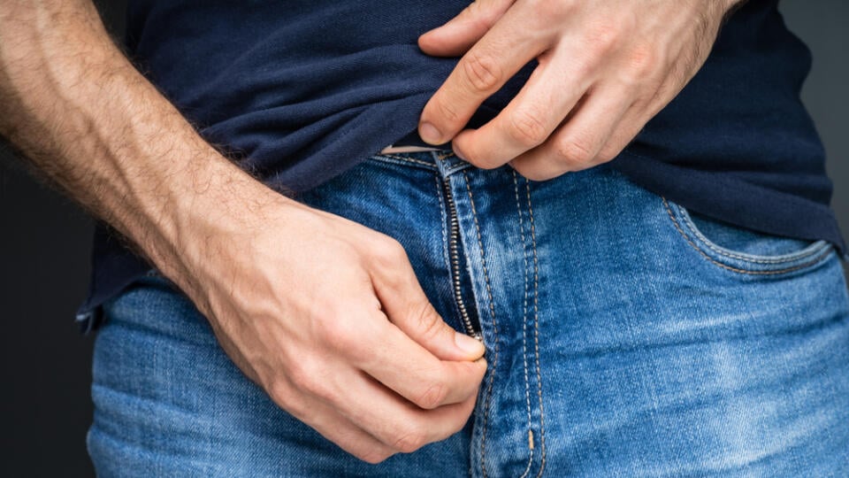 Close-up,Of,A,Man's,Hand,Unzipping,His,Blue,Denim,Jeans