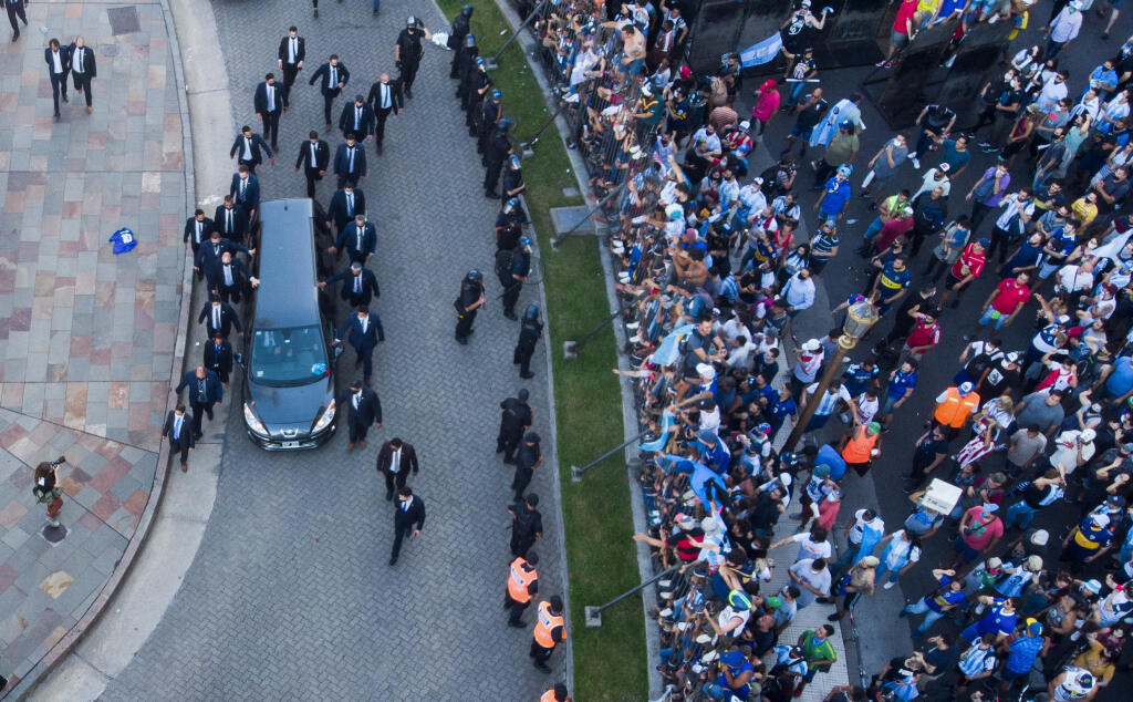KK7 Buenos Aires - Na snímke pohrebný voz vezie truhlu s pozostatkami Diega Maradonu z prezidentského paláca, kde bola vystavená 26. novembra 2020 v Buenos Aires. Telo futbalistu Diega Maradonu vo štvrtok vystavili v sídle argentínskej federálnej vlády. O osobnú rozlúčku prejavili záujem davy ľudí. Neskôr sa však situácia vyhrotila, fanúšikovia sa v snahe dostať dnu hádzali na policajtov fľašky či kusy oplotenia. Bezpečnostné zložky v jednom prípade použili slzotvorný plyn. Maradona zomrel v s