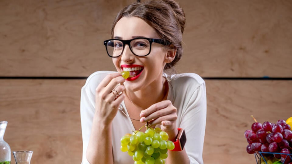 Young,And,Cute,Woman,Eating,Grapes,At,The,Table,Full