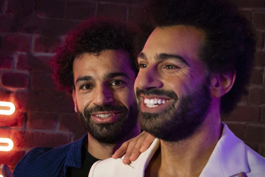 Na snímke vľavo egyptský útočník anglického futbalového klubu FC Liverpool Mohamed Salah pózuje vedľa svojej voskovej figuríny počas uvedenia v múzeu voskových figurín Madame Tussauds v Londýne 16. októbra 2021.