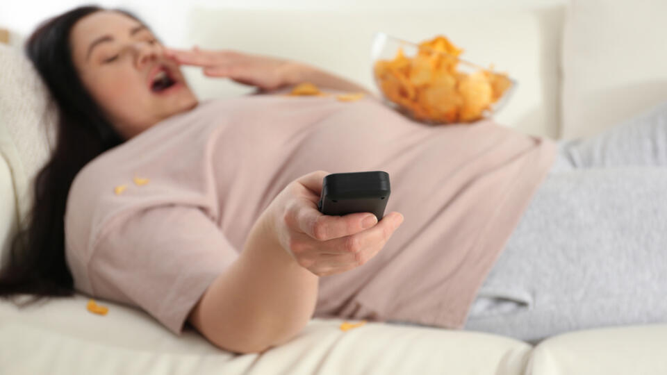 Lazy,Overweight,Woman,With,Chips,Watching,Tv,At,Home,,Focus