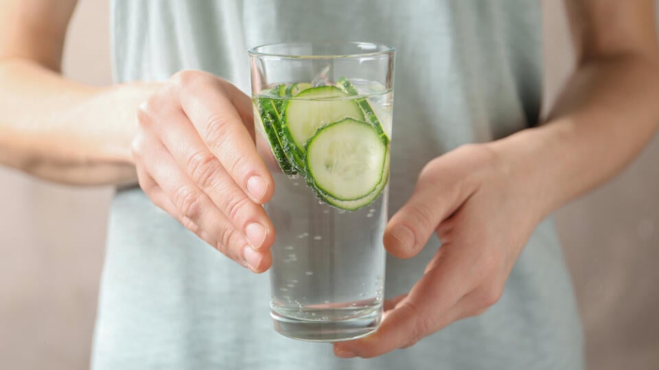 Young,Woman,Holding,Glass,With,Fresh,Cucumber,Water,,Closeup